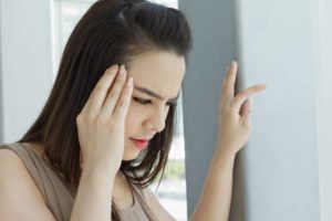 Distressed-woman-touching-hand-to-forehead