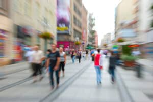 Motion blurred image of people walking along pedestrian shopping street