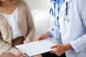 Close-up of physician with clipboard and female patient