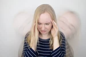 Woman with headache, dizzy, transparent images of her in background